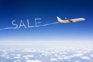 plane flying Airplane flying through the sky with word "Sale" written in the clouds.